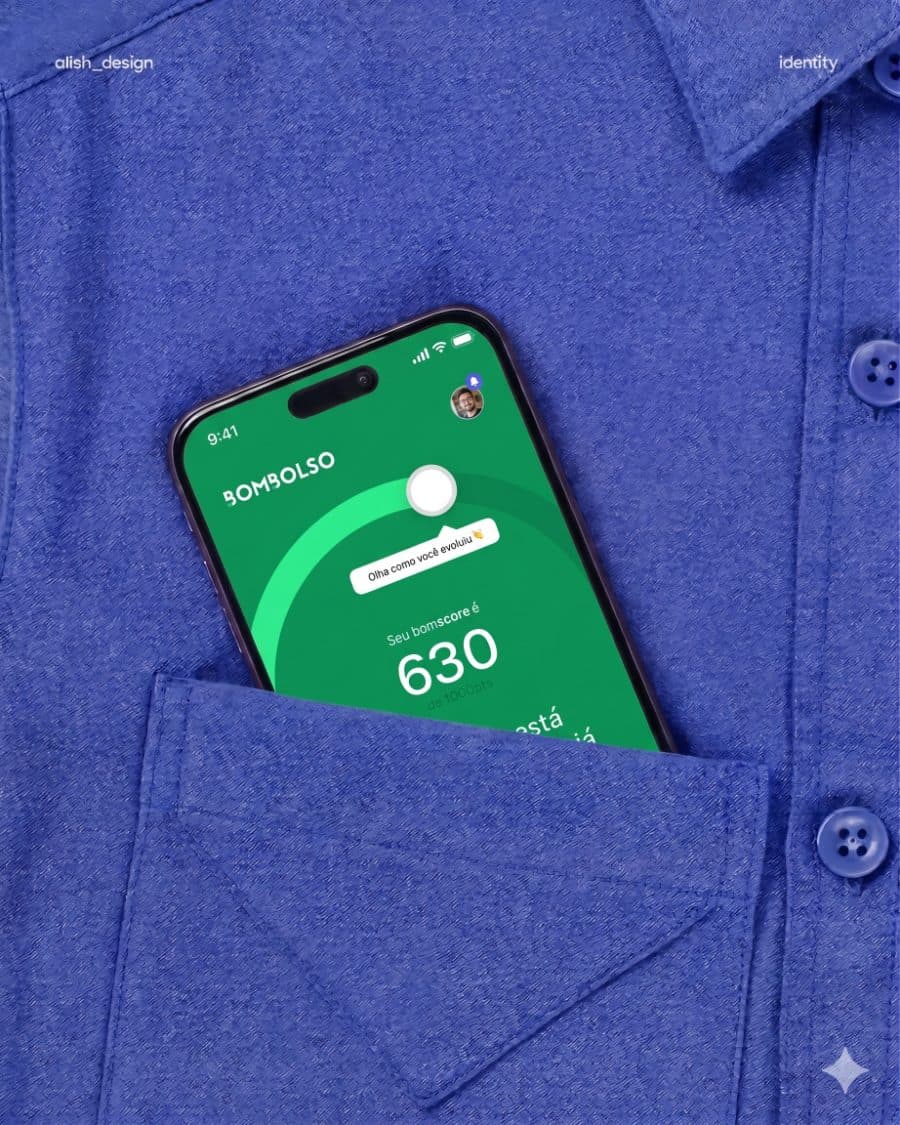 Celular no bolso de uma camisa azul mostrando o app Bombolso com o score